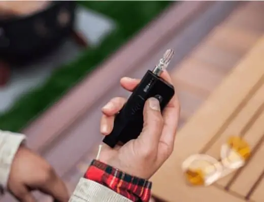 a person using a Dip Device for vaping.