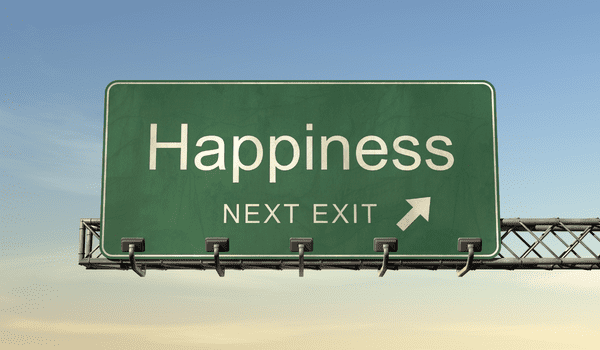 A green highway sign shows the text Happiness with a caption below it stating Next Exit