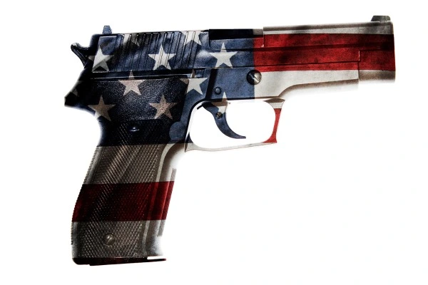 A handgun is colored to look like the red, white and blue flag of the USA. 