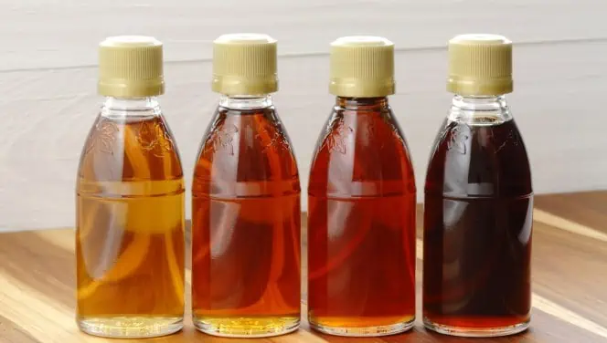 Four bottles of amber colored natural alternatives to corn syrup.

