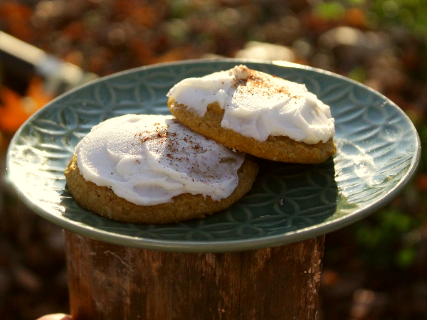Cannabis-infused pumpkin cookies with icing on a plate outdoors. 
