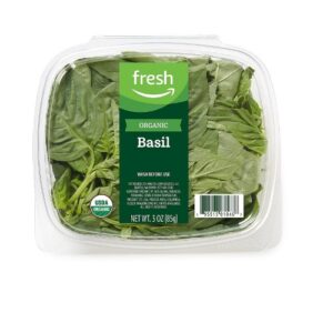 Fresh organic spinach in a plastic container.