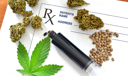 A doctor's prescription and marijuana leaves on a table.
