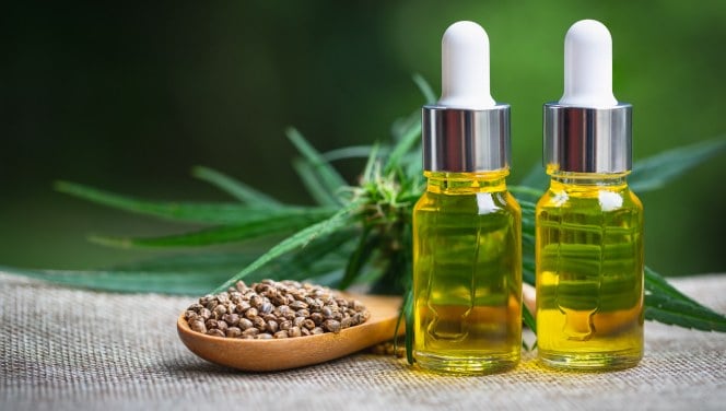 Cannabis-infused CBD oil and seeds showcased against a green backdrop.
