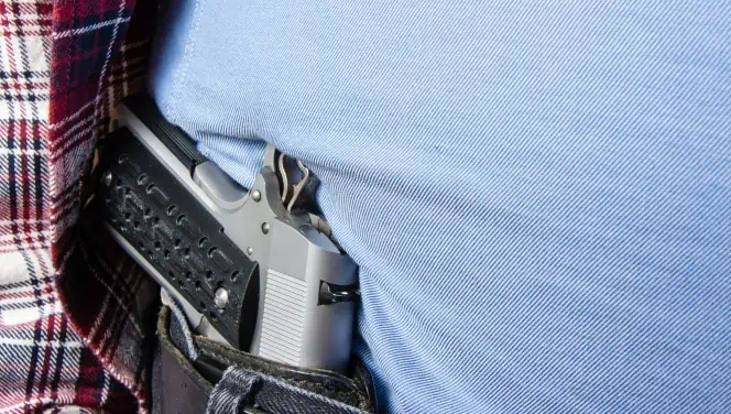 A man carries his firearm in his right hip