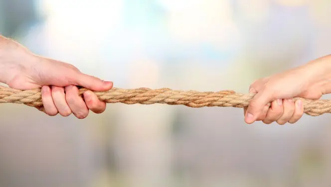 Two hands pull against a rope in a tug of war